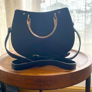 Black with gold hardware women’s purse can be used as a clutch or cross body.